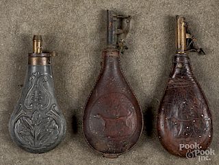 Two embossed leather powder flasks, etc.