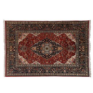 Tapete. Irán, Mashad, siglo XX. Elaborado en fibras de lana y algodón. Decorado con medallón central y orgánicos sobre fondo rojo.
