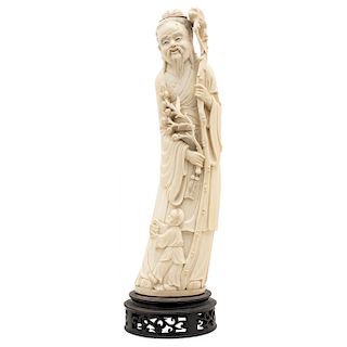 SHOU XING. CHINA, 20TH CENTURY. Carved ivory with black ink details. Includes wooden base. 