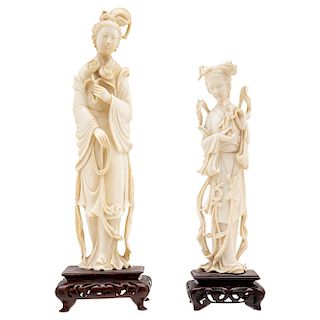 A PAIR OF CHINESE LADYS. BEGINNING OF THE 20TH CENTURY. Carved ivory with wooden bases. One carries flowers and the other carries a figure of Guan Yin