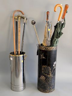 Two umbrella holders with umbrellas and canes, one holder painted along with fire extinguisher or artillery shell made into umbrella...