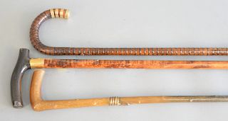 Three canes to include one horn with plated snake; two wood with gold rings, one being marked Brigg London, along with one being mon...