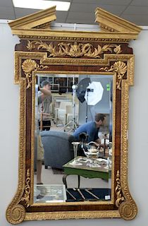 A George II style parcel gilt walnut mirror, the broken triangular pediment over a shaped back plate with outset corners applied wit...