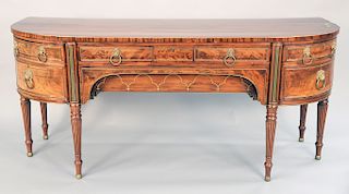 Regency brass mounted mahogany and rosewood sideboard, D-form, the center with a long drawer over a shaped frieze drawer, centered b...