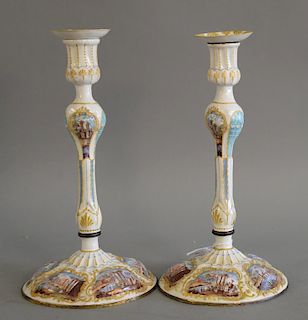 Pair of copper mounted staffordshire enamel candlesticks with white ground, each with five enameled landscape scene around base, cir...