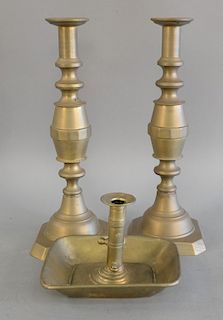 Three piece lot to include pair of large brass push up candlesticks and one brass chamberstick. ht. 14 1/4 in.