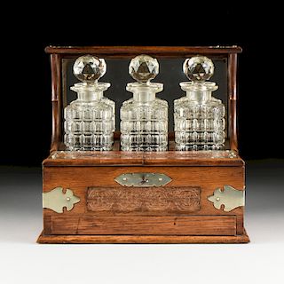 AN ENGLISH GOTHIC REVIVAL BRONZE MOUNTED OAK TANTALUS AND CUT GLASS DECANTERS SET, CIRCA 1900,