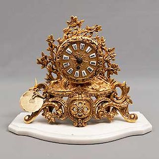 Reloj de chimenea. México. SXX. Elaborado y cincelado a mano en bronce. Mecanismo de cuerda y base de mármol. 25 x 28 x 10 cm.