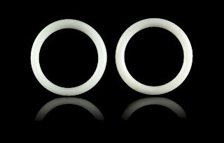 A Pair of Chinese White Hardstone Bangles
Each interior: diam 2 1/2 in., 6 cm. 