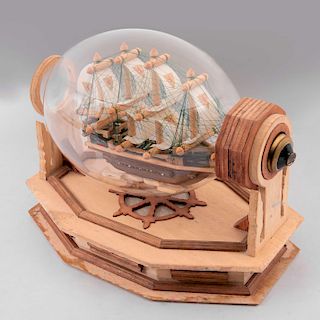 Barco decorativo. Elaborado en madera con aplicaciones de nylon, encapsulado en bombilla con soporte de madera.