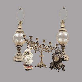 Lote mixto de 5 piezas. Origen europeo y estadounidense. Siglo XX. Consta de: Reloj de mesa, dama, candelabro y par de lámparas.