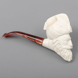 Pipa. SXX. En talla de espuma de mar con boquilla de pasta. Decorada con mascarón de hombre barbado con turbante. 7 x 4 x 14 cm.