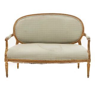 Sofá. Siglo XX. Estilo Luis XVI. En talla de madera dorada. Con respaldo cerrado y asiento acojinado en tapicería cuadriculada.