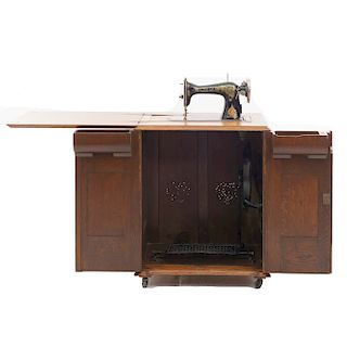 Máquina de coser. Estados Unidos. Siglo XX. Marca Singer. Mecanismo Eléctrico. Mueble en talla de madera. 100 x 156 x 59 cm.