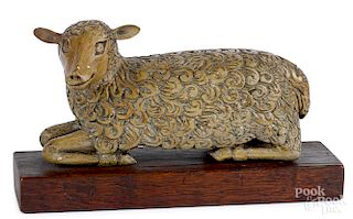 Carved and painted reclining lamb