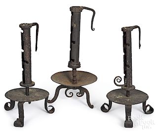 Three wrought iron adjustable candlesticks