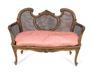 A Louis XV Style Giltwood and Caned Canape
Height 35 x width 48 x depth 20 inches.