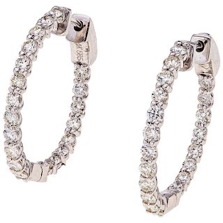 A diamond 14K white gold pair of hoop earings. 