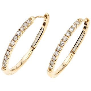 A diamond 14K yellow gold pair of hoop earrings. 