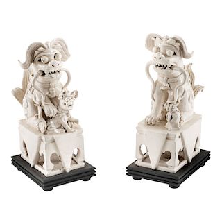 PAIR OF LIONS. CHINA, SIGLO XX. White porcelain with wooden base. 13.3 in each one