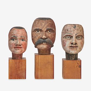 THREE CARVED AND PAINTED HEADS