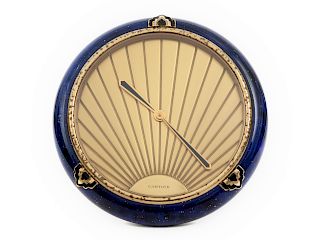 A Cartier Art Deco Style Desk Clock
20TH CENTURY
having a circular brass case decorated with blue lapis lazuli colored enamel; Swiss made Quartz movem