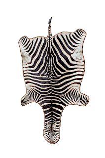 A Zebra Skin Rug
20TH CENTURY
Length 116 inches.