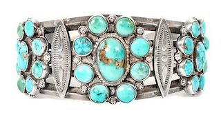 A Silver and Turquoise Cluster Bracelet Length 5 1/2 x opening 1 1/4 x width 1 14 inches.