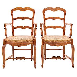 Par de sillones. Francia. Siglo XX. En talla de madera de roble. Con respaldos semiabiertos y asientos de palma tejida.