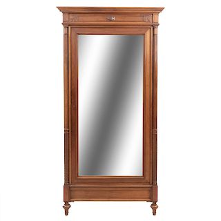 Armario. Francia. SXX. En talla de madera de nogal. Puerta con espejo de luna biselada y cajón interno. 218 x 100 x 50 cm.