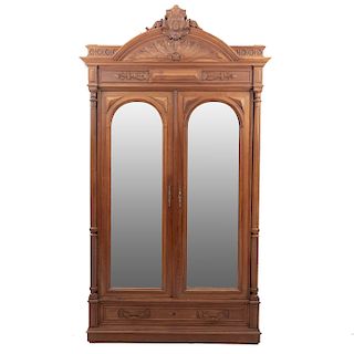 Armario. Francia. Siglo XX. Estilo Enrique II. En talla de madera de nogal. 2 puertas con espejo de luna biselada. 262 x 136 x 50 cm.