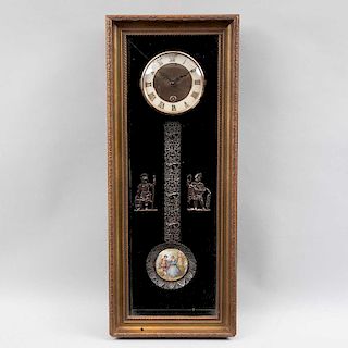 Reloj de pared. Alemania, siglo XX. Estructura de madera tallada. Mecanismo de cuerda. Carátula dorada con índices romanos.