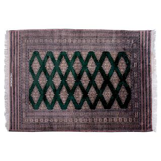 Tapete. Pakistán, siglo XX. Estilo Bokhara. Elaborado en fibras de lana, algodón y ensedado. Decorado con motivos geométricos.