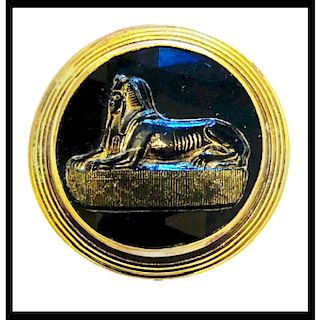 A FACETED AND GLUED SPHINX OVER BLACK GLASS BUTTON