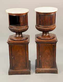 Pair of mahogany classical style cabinets with marble top, urn form having tambour doors, set on square cabinets with one door, probably 19th century.