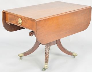 Duncan Phyfe mahogany drop leaf table, with false drawers and carved pedestal set on four downswept members ending in brass paw feet. height 29 inches