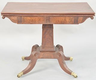 Federal mahogany games table, having rectangular top on square shaft on base with four downswept members, ending in brass capped feet. height 29 3/4 i