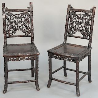 A pair of 19th century Chinese hardwood child's chairs, each with rectangular back pierced with naturalistic foliage above solid bowed seat on splayed