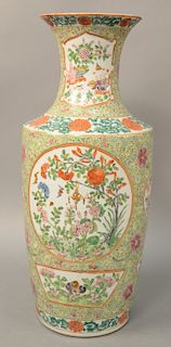 Famille Rose baluster vase, China, 19th century decorated with pink and orange floral reserves on a green ground, height: 18 inches.