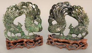 Pair of spinach green jade bird groups, each having crested male and female peacocks standing on carved rock base mounted on carved hardwood stand, Pa