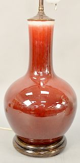 Oxblood bottle vase (tianqiuping), China 19th/20th century, with dark, rich overall glaze and cream colored interior and base, which is drilled, heigh