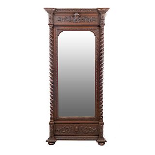 Armario. Francia. Siglo XX. En talla de madera de nogal. Puerta abatible con espejo de luna rectangular y cajón. 240 x 110 x 53 cm.