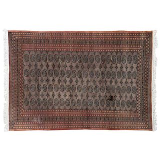 Tapete. Pakistán, siglo XX. Estilo Bokhara. Elaborado en fibras de lana, algodón y ensedado sobre fondo café.