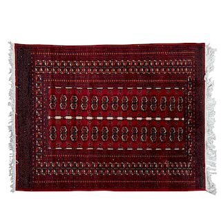 Tapete. Pakistán, siglo XX. Estilo Bokhara. Elaborado en fibras de lana y algodón. Decorado con motivos geométricos.