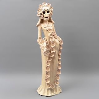 Catrina vestida de novia. México. SXX. En barro policromado y esmaltado. En colores beige y rosado. Con vestido y velo. 59 x 18 x 17 cm