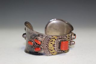 Silver bangle with red coral decorations.