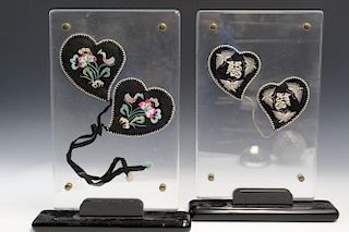 Two pairs of Chinese embroidery ear muffs, framed.