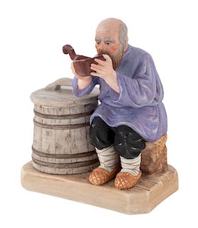 A RUSSIAN PORCELAIN FIGURE OF A PEASANT DRINKING FROM A KOVSH, GARDNER PORCELAIN FACTORY, VERBILKI, MOSCOW, 1870S-1890S