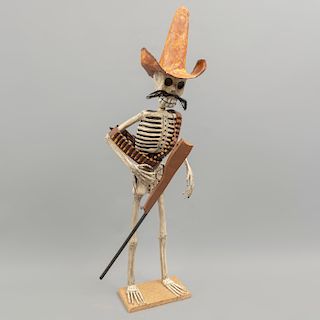 Esqueleto revolucionario. México. Siglo XX. En papel maché. Con bigote, sombrero, carrilleras de balas y Carabina. 67 x 20 x 19 cm.