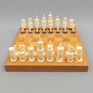 Juego de ajedrez. Siglo XX. En talla de madera y hueso. Consta de: caja-tablero y 32 piezas móviles de hueso. 35 x 35 x 4 cm. Piezas:33
